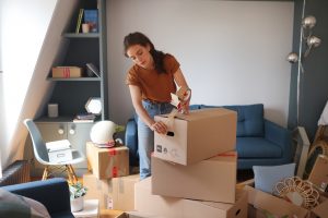 Una chica embala las cajas con sus pertenencias.