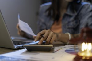 Una chica revisando sus rentas con una calculadora.