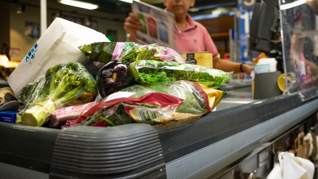 Varios productos y verduras en la caja del Carrefour.