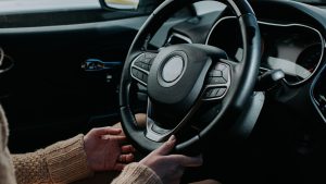 Female hands holding steering wheel in a Car