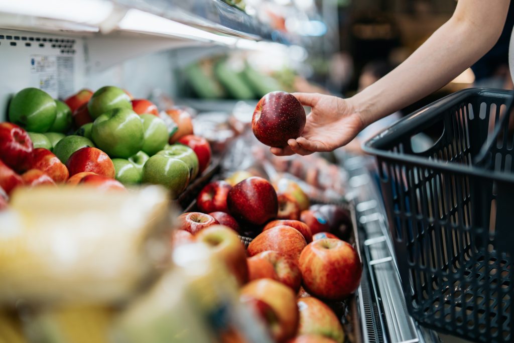 Una chica comprando fruta en el supermercado.