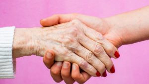 two women's hands, one old and one young, union