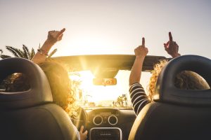 Dos amigas al volante cantando canciones en el coche.