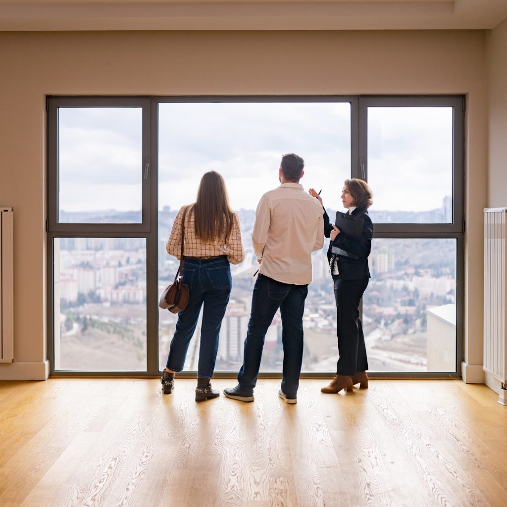 Una agente inmobiliaria mostrando su casa a una pareja joven.