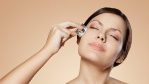 woman holding ice cube on her face