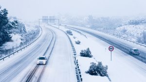 Cars driving on a snowy road.