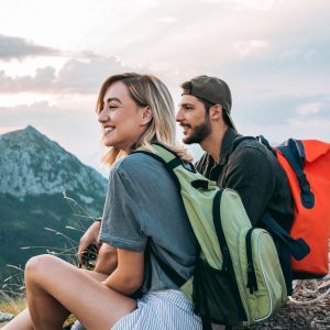 beautiful young couple relaxing after hiking and taking a break