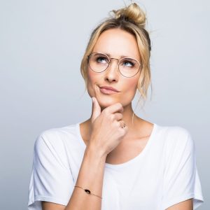 Thoughtful woman with hand on chin looking up