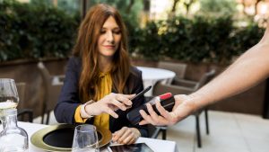 Woman paying with smartphone in a restaurant