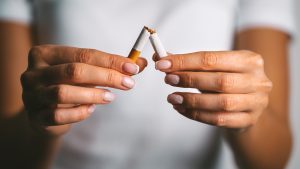 Woman brakes cigarette in hands. Woman refusing tobacco. Stop smoking, quit smoking or no smoking cigarettes