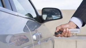 Hispanic businessman using electronic key to open car door