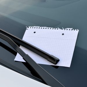 blank sheet of paper under a windshield wiper