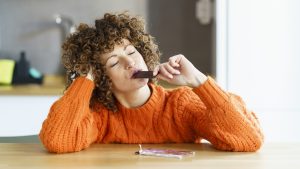 Woman with eyes closed enjoying chocolate at home