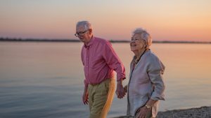 A senior couple enjoying summer vacation by the sea, celebrating their wedding anniversary.